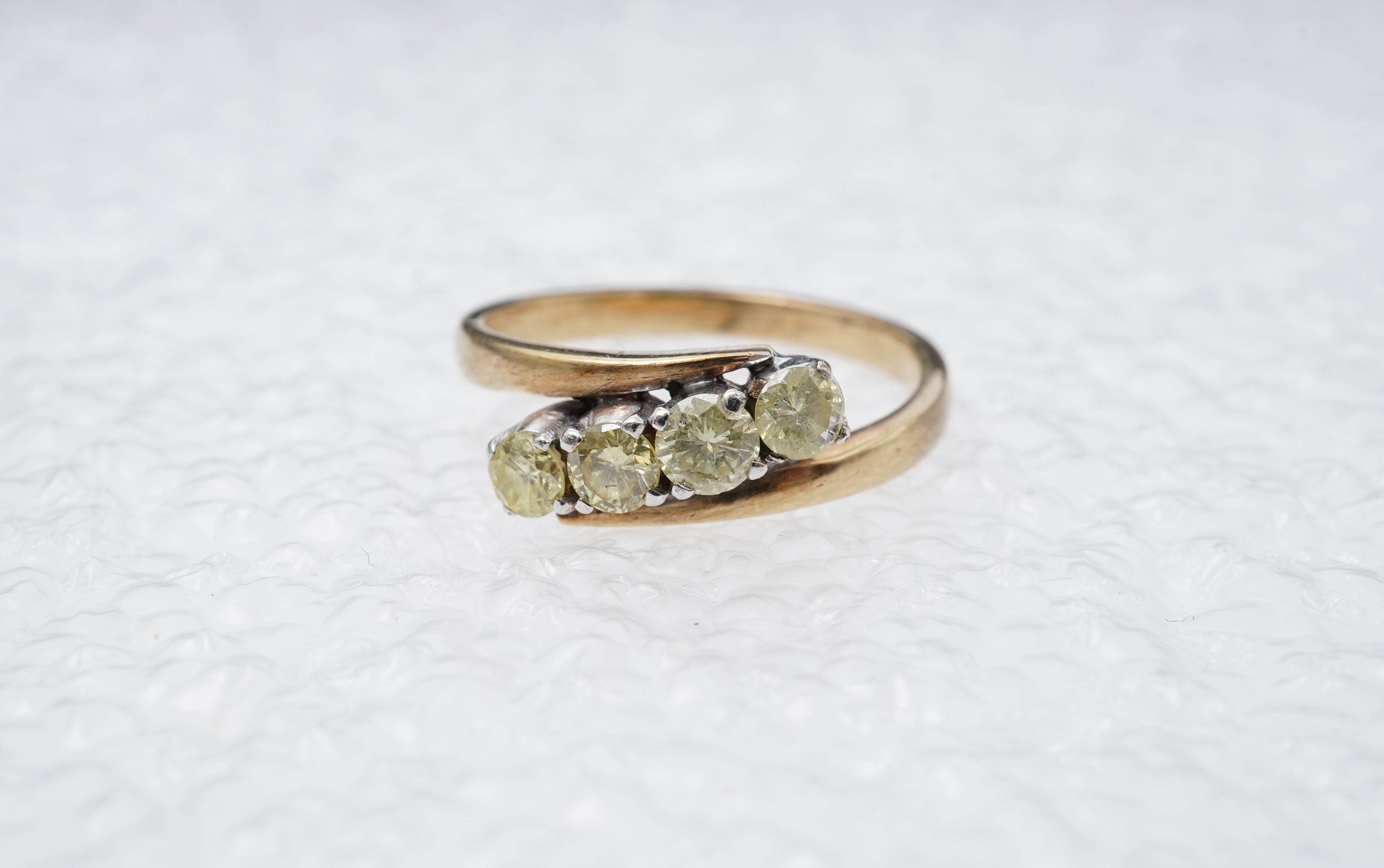 A yellow diamond ring, claw-set with four brilliant-cut diamonds of yellow tint totalling approximately 0.40 carats, mounted in gold, gross weight approximately 2 grams